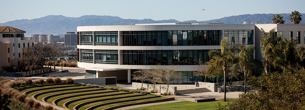 William H. Hannon library from a distance with Lawton Plaza in the foreground and the Los Angeles skyline in the background.